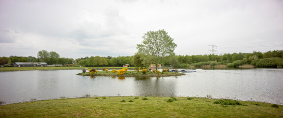 Island in middle of wide angle panorama landscape of recreational pond Lageveld in Wierden with picnic field and leisure area