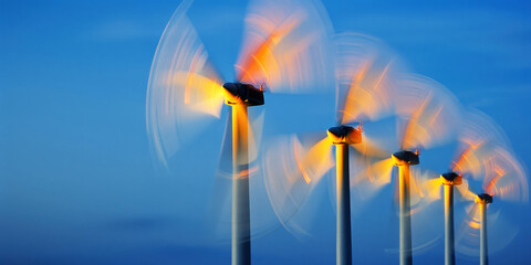Glowing wind turbines at night, dynamic motion on the sea