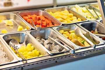A fruit tray with a variety of fruits including apples, pine apple, papaya  and grape