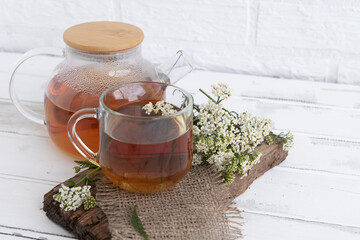 tea in a teapot (decoction)from the leaves and flowers of medicinal yarrow (Achillea) in a cup....