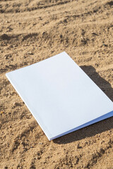 blank magazine mockup on sandy beach