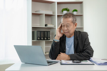 Financial data analysis, senior Asian businessman working with documents in office, having a...