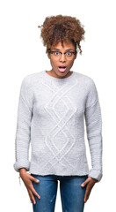 Beautiful young african american woman wearing winter sweater over isolated background afraid and...
