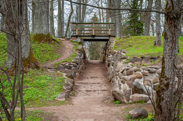 Walkway in the Burtnieku manor park. Pedestrian bridge creates two levels of pathways through the...