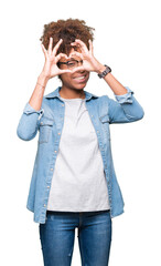 Beautiful young african american woman wearing glasses over isolated background Doing heart shape with hand and fingers smiling looking through sign