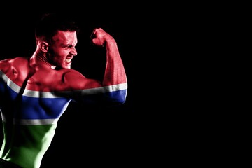 Gambia flag handsome young muscular man black background