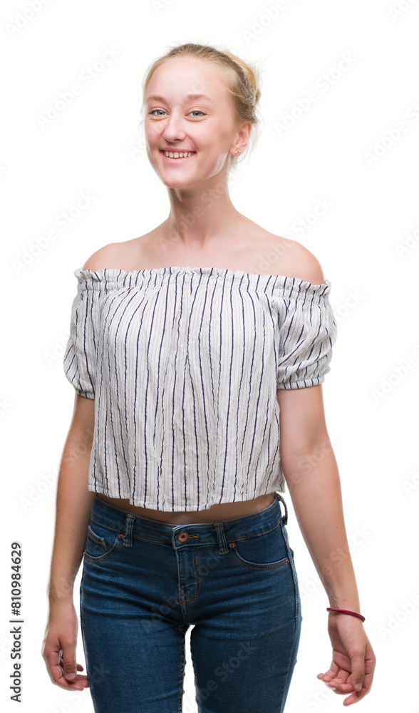 Wall mural Blonde teenager woman wearing a bun with a happy face standing and smiling with a confident smile showing teeth