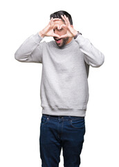 Fototapeta premium Young handsome man wearing sweatshirt over isolated background Doing heart shape with hand and fingers smiling looking through sign