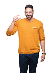 Young handsome man over isolated background smiling and confident gesturing with hand doing size sign with fingers while looking and the camera. Measure concept.