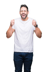 Young man wearing casual white t-shirt over isolated background excited for success with arms raised celebrating victory smiling. Winner concept.