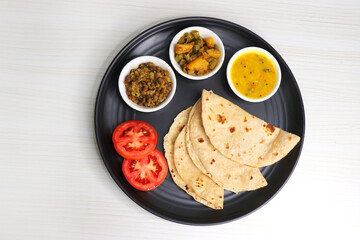 Roti and bhaji. Indian vegetarian Thali or platter includes akhha Masoor sabzi, dal, fansi or beans...