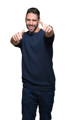 Young handsome man wearing sweater over isolated background approving doing positive gesture with hand, thumbs up smiling and happy for success. Looking at the camera, winner gesture.