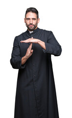 Young Christian priest over isolated background Doing time out gesture with hands, frustrated and...