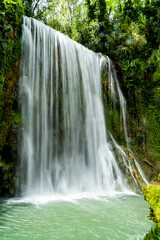 Vertical long exposure daytime shot of La Caprichosa, a huge waterfall in a stone monastery in Spain. With the water with silk effect as it falls.