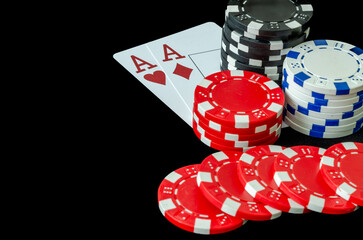 Poker chips and cards in a casino on a black background