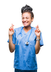 Young braided hair african american girl professional surgeon over isolated background smiling crossing fingers with hope and eyes closed. Luck and superstitious concept.