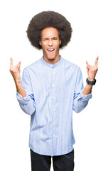 Young african american man with afro hair shouting with crazy expression doing rock symbol with...