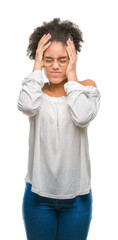 Young afro american woman wearing glasses over isolated background suffering from headache desperate and stressed because pain and migraine. Hands on head.