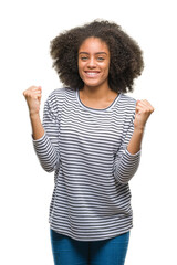 Young afro american woman over isolated background celebrating surprised and amazed for success with arms raised and open eyes. Winner concept.