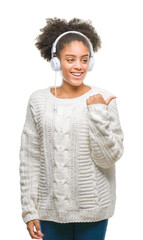 Young afro american woman wearing headphones over isolated background pointing and showing with...