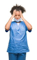 Young afro american doctor woman over isolated background suffering from headache desperate and...