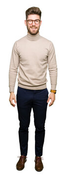 Young handsome business man wearing glasses winking looking at the camera with sexy expression, cheerful and happy face.