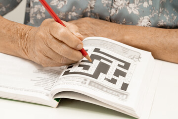 Alzheimer disease AD, Asian elderly woman playing sudoku puzzle game to practice for dementia...