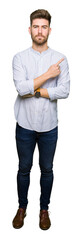 Obraz premium Young handsome man Pointing with hand finger to the side showing advertisement, serious and calm face
