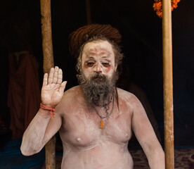 Portrait of an holy male naga sadhu baba with ash on his and long hairs wearning rudraksha necklace...