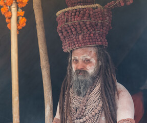Portrait of an holy male naga sadhu baba with ash on his and long hairs wearning rudraksha necklace...