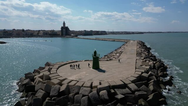 Overview of the marina. Beautiful summer day with blue sky and white clouds. Cathedral of San Nicola Pellegrino.