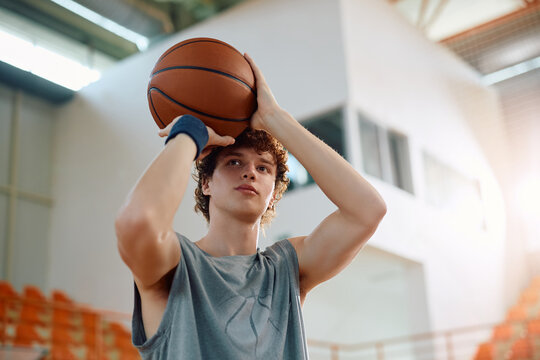 Young basketball player shooting at hoop during sports training. - Powered by Adobe