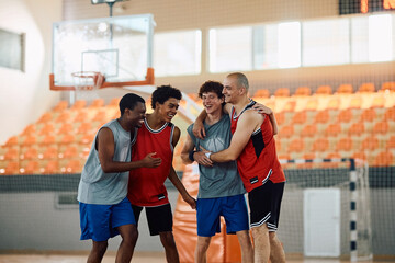 Team of cheerful basketball players having fun on court.