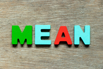 Color alphabet letter in word mean on wood background