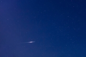 Milky Way stars, meteor falling star trail and night sky photographed with wide angle lens.