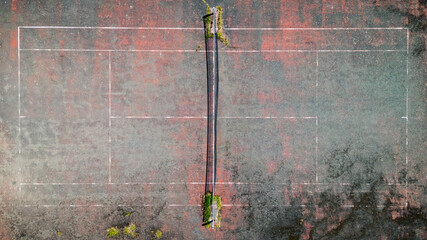 Top down view of a run down outdoor tennis court 