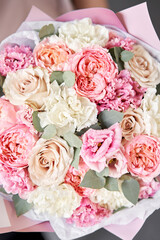 Small Beautiful bouquets of mixed flowers in woman hand. Floral shop concept . Beautiful fresh cut bouquet. Flowers delivery