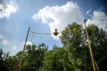 The boy is jumping on a bungee trampoline. A child with insurance and stretchable rubber bands...