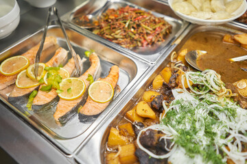 Salmon fillet. Various hot dishes . Glass Showcase in a buffet or self-service restaurant.
