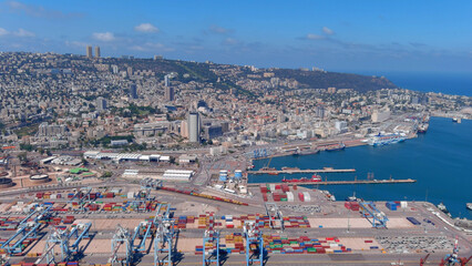 Haifa port with cranes containers and ships, sunrise, 2022 
Drone view over cranes and cargo...