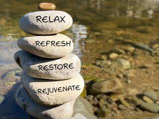Relax, restore, refresh and rejuvenate text written on pebbles stack with nature background ...