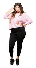Young beautiful woman wearing pink sweater smiling doing phone gesture with hand and fingers like talking on the telephone. Communicating concepts.