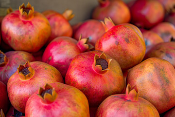 pomegranates on market, The pomegranates are arranged in a captivating display, their round shapes creating a sense of abundance and fertility
