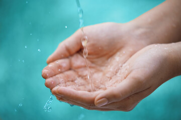 Person, hands and water splash with drops for natural hydration, hygiene or sustainability on a...