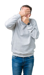 Handsome middle age senior man wearing a sweatshirt over isolated background Covering eyes and mouth with hands, surprised and shocked. Hiding emotion