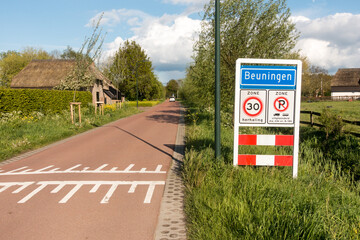 Place name sign for the village of Beuningen, the Netherlands, on a sunny day in spring (also speed limit of 30 km per hour, and no parking for trucks or buses)