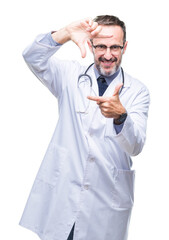Middle age senior hoary doctor man wearing medical uniform isolated background smiling making frame with hands and fingers with happy face. Creativity and photography concept.