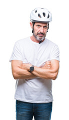 Middle age senior hoary cyclist man wearing bike safety helment isolated background skeptic and nervous, disapproving expression on face with crossed arms. Negative person.