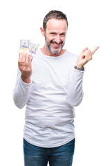 Senior hoary man holding buch of dollars over isolated background very happy pointing with hand and finger to the side
