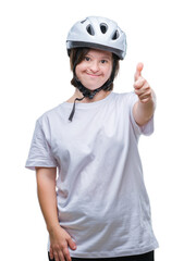 Young adult cyclist woman with down syndrome wearing safety helmet over isolated background doing happy thumbs up gesture with hand. Approving expression looking at the camera with showing success.